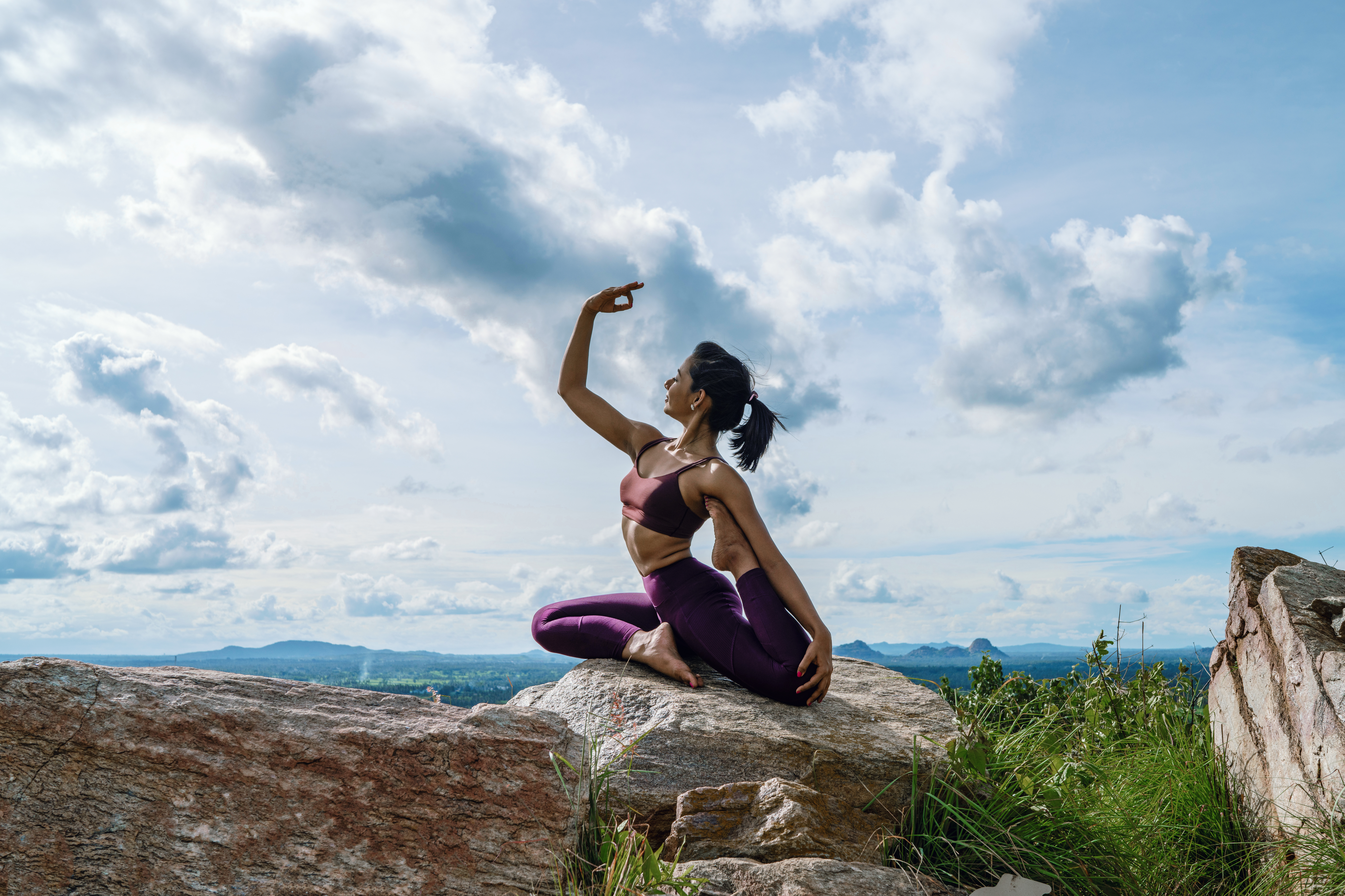 Sushmitha doing a yoga pose on a mountain