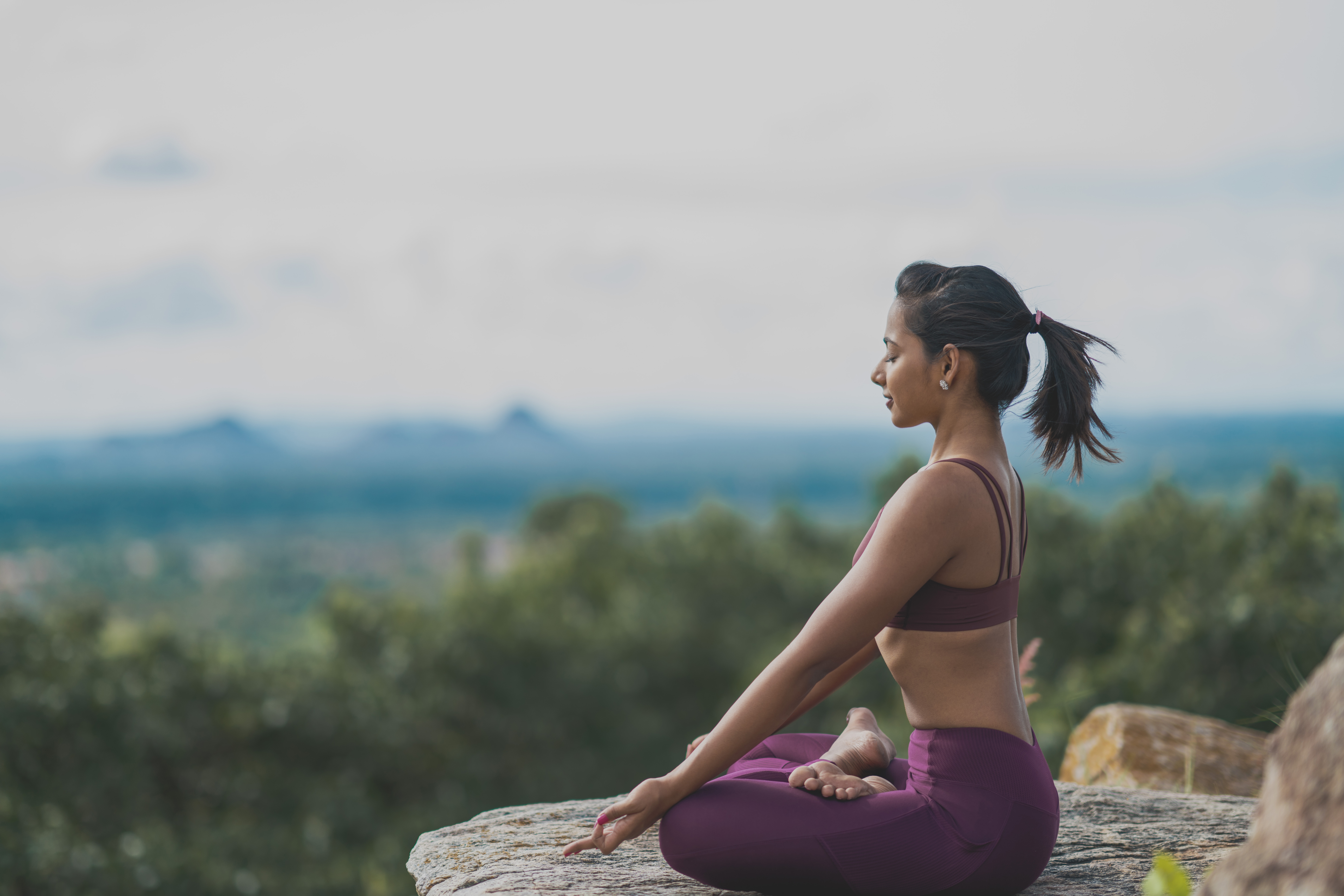 Sushmitha meditating on a mountain